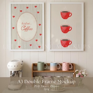 May include: Two framed art prints with a coffee theme. One says "but first... Coffee" with red coffee cups. The other shows three red coffee cups. Below, a wooden shelf displays mugs in various colours.