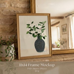 May include: A framed 11x14 inch mockup featuring a gold frame with a floral illustration. The artwork depicts white flowers and green leaves in a black and white dotted vase. The frame is displayed on a stone surface.