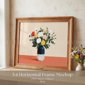 May include: A framed art print featuring a floral still life in a navy blue vase with a speckled base. The artwork is set against a peach background with a red horizontal line. The frame is made of light brown wood. The text "5:4 Horizontal Frame Mockup" is at the bottom.