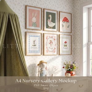 Op de afbeelding: Een mockup van een galerijmuur voor een kinderkamer met zes ingelijste kunstdrukken, waaronder illustraties van een konijn, gans en paddenstoelen. Een knuffelkonijn in een tuinbroek en hoed zit eronder. De tekst "A4 Nursery Gallery Mockup" staat onderaan.