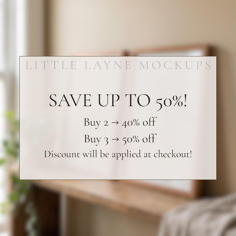 May include: A white rectangular sign with the text "LITTLE LAYNE MOCKUPS" at the top. The sign says "SAVE UP TO 50%!" with details on discounts for buying multiple items. The background is a blurred interior.
