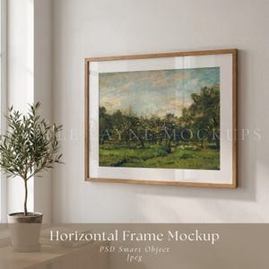 以下が含まれることがあります： 白い壁に、明るい木枠の額に入った風景画が飾られています。アートワークは、緑の野原、木々、青い空を描いています。額の下の棚には小さな鉢植えの植物があります。「Horizontal Frame Mockup」という文字が見えます。