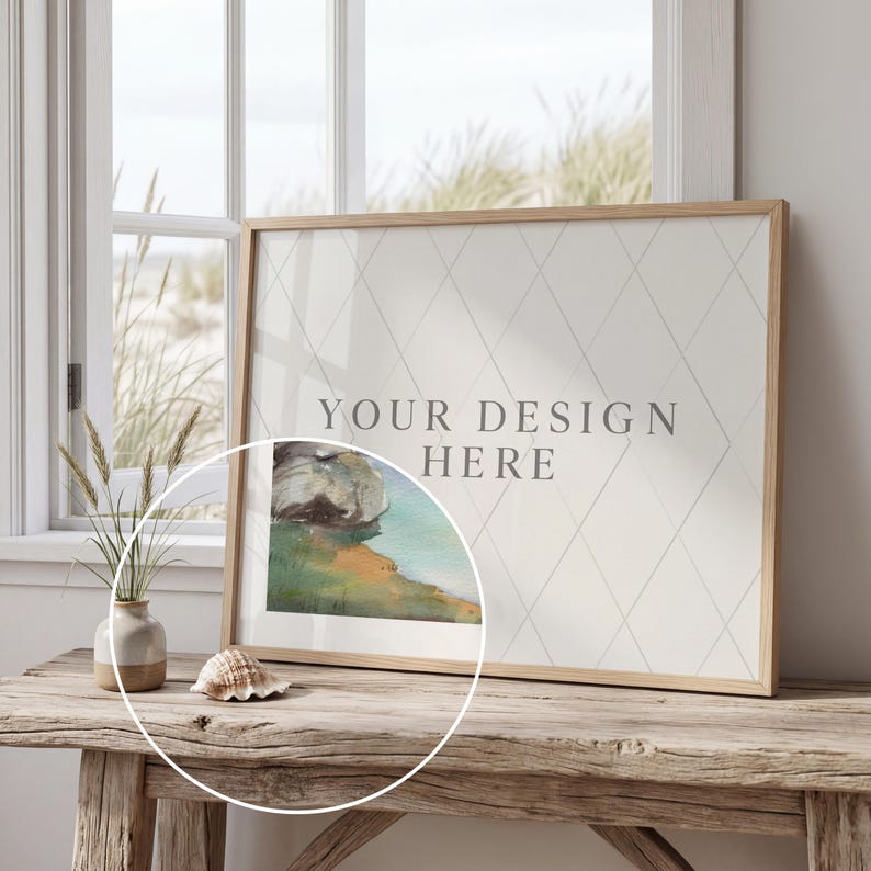 May include: A framed print with the text "YOUR DESIGN HERE" on a rustic wooden table. The artwork features a watercolor landscape. A seashell and a small vase with dried plants are also on the table.