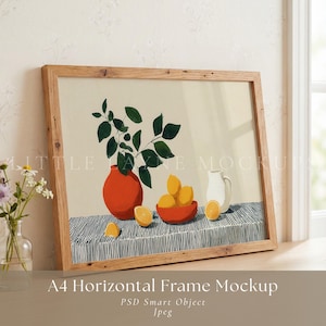 May include: A framed art print featuring a still life composition. The artwork depicts a red vase with green leaves, a bowl of lemons, and a white pitcher on a striped surface. The frame is made of light-colored wood.