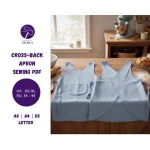 以下が含まれることがあります： 木製の表面に展示された、ポケット付きの薄い青色のクロスバックエプロン2つ。エプロンはソーイングPDFの一部で、米国ではXSからXL、EUでは34〜44のサイズオプションがあります。「Sewing by Shaila」のテキストも含まれています。
