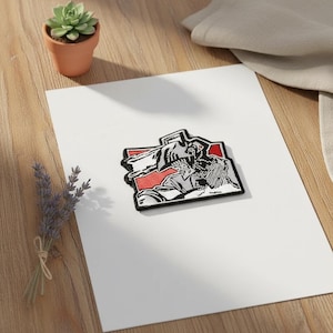 Può includere: Toppa ricamata raffigurante un personaggio con la testa a motosega, su sfondo rosso e nero. La toppa è rettangolare con bordo nero, adatta per giacche, borse o altri articoli in tessuto.