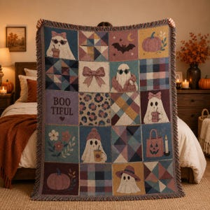 May include: A woven throw blanket featuring a patchwork design with various squares. The pattern includes ghosts wearing sunglasses, bows, pumpkins, bats, flowers, and plaid motifs. The text "BOO TIFUL" is printed on one square. The blanket has fringed edges.