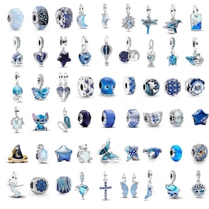 May include: A selection of silver charms and beads in various shades of blue. Designs include stars, hearts, butterflies, and other decorative shapes. Some charms have dangling elements, and others are spherical or cylindrical.