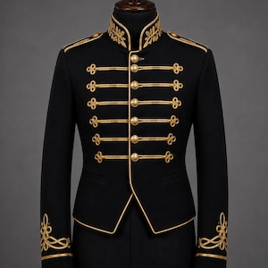 Op de afbeelding: Een zwarte jas in militaire stijl met een hoge kraag met gouden bladborduursels, gouden biezen langs de randen en zes rijen horizontale gouden koordversieringen met bijpassende gouden knopen aan de voorzijde en op de mouwboorden.