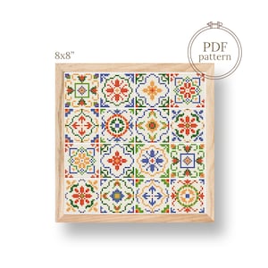 May include: A framed cross-stitch pattern featuring a colorful tile design. The pattern includes red, orange, blue, green, and yellow geometric shapes. The frame is light wood, and the dimensions are 8x8 inches.
