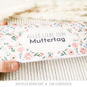 Könnte beinhalten: Eine rechteckige Karte mit floralem Design und dem Text "ALLES LIEBE ZUM Muttertag" in der Mitte. Die Karte ist von einem Kranz aus rosa, lila und weißen Blumen und grünen Blättern umgeben. Die Worte "DIGITALER DOWNLOAD • ZUM AUSDRUCKEN" stehen unten.