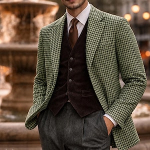 Könnte beinhalten: Ein Mann in einem grün-schwarzen Hahnentritt-Blazer, einer braunen Cordweste, einem weißen Hemd, einer braunen Krawatte und einer grauen Hose. Das Logo von The Stag's Era ist unten links zu sehen. Geeignet für formelle Anlässe.