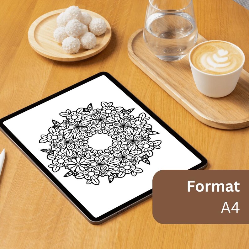 May include: A tablet displaying a black and white floral wreath line art illustration on its screen. A brown box in the corner contains the white text Format A4. The tablet is placed on a wooden surface next to a plate of coconut treats.