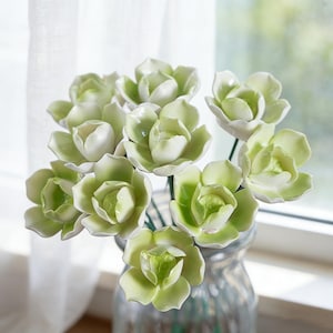 Puede incluir: Un juego de tres tazas de cerámica con un acabado moteado y mate. Las tazas son de color crema, gris claro y gris oscuro. Cada taza tiene un diseño simple y minimalista.