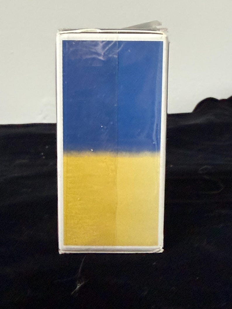 May include: A rectangular box with a blue top half and a yellow bottom half. The box has a white border and is set against a dark background.