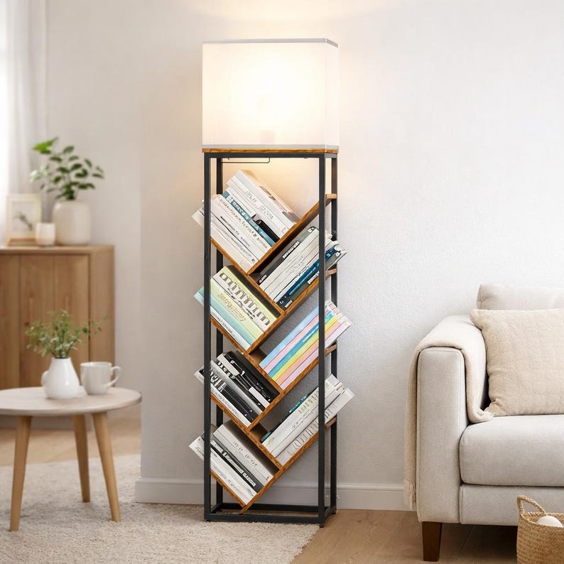Pode incluir: Candeeiro de p&eacute; com estante embutida. O candeeiro tem um abajur retangular branco e uma estrutura de metal escuro. A estante, feita de madeira, cont&eacute;m v&aacute;rios livros. O candeeiro est&aacute; numa sala de estar.