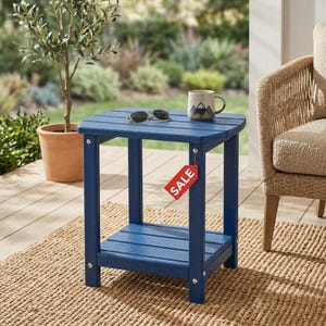 May include: A blue outdoor side table with a slatted top and lower shelf. The table has a red "SALE" tag attached. Sunglasses and a mug with a mountain design are on the table. The table is on a woven rug.