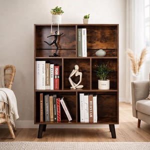 May include: A dark brown wooden bookshelf with multiple compartments, filled with books, decorative items, and small potted plants. The bookshelf has a mid-century modern design with black legs and a distressed finish.