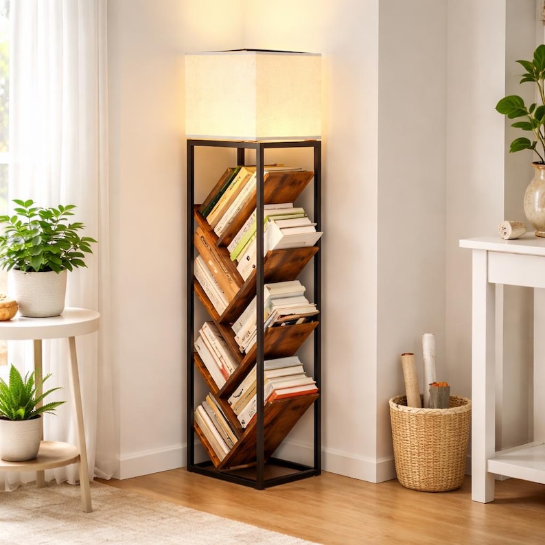 Pode incluir: Candeeiro de p&eacute; com estante embutida. O candeeiro tem um abajur quadrado creme sobre uma estante de madeira. A estante est&aacute; integrada numa estrutura de metal preto e cont&eacute;m v&aacute;rios livros. A sala &eacute; luminosa, com plantas e uma mesa lateral branca.