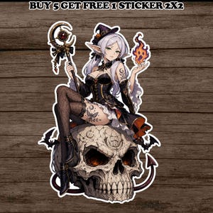 May include: A die-cut sticker featuring an anime-style witch with silver hair, wearing a black dress and holding a staff and a flame. The witch sits atop a large, detailed skull decorated with moon symbols. Text at the top reads BUY 5 GET FREE 1 STICKER 2X2.