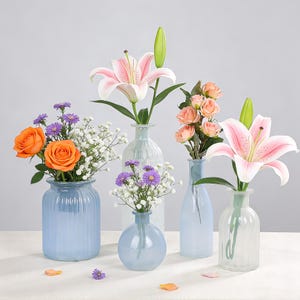 May include: A collection of glass vases in various shapes and sizes, each holding different types of flowers. The flowers include orange roses, pink lilies, and peach-colored roses. The vases are in shades of blue and clear.