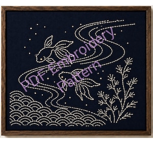 May include: Embroidered artwork featuring two goldfish swimming in a stylized river, with white stitching on a dark blue background. The design includes water waves, aquatic plants, and the text "PDF Embroidery Pattern". The artwork is framed in a dark wood frame.