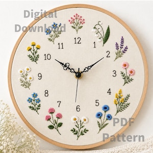 Puede incluir: Un reloj de pared redondo con una esfera de tela clara que presenta motivos florales bordados en cada marca de hora. El reloj tiene manecillas y números negros. El texto Digital Download y PDF Pattern es visible en la esfera del reloj.