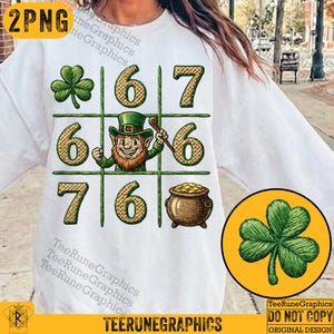 Puede incluir: Sudadera blanca con un diseño del Día de San Patricio. El gráfico incluye un juego de tres en raya con un duende, un trébol y una olla de oro. El texto "TeeRuneGraphics" está en la parte inferior.