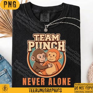 May include: Black t-shirt with the words "TEAM PUNCH" and "NEVER ALONE" printed on it. The graphic features two cartoon monkeys hugging. A silver chain necklace with a pendant is also visible.