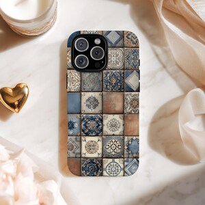 May include: A smartphone case featuring a mosaic tile design in shades of blue, beige, and brown. The case has a glossy finish and a square tile pattern. The design includes floral and geometric motifs, creating a vintage aesthetic.