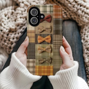 Puede incluir: Una funda para smartphone con un diseño de patchwork de varios patrones de cuadros y tartán en tonos marrón, beige, naranja y verde oliva, decorada con cinco pequeños lazos texturizados dispuestos en una columna vertical.