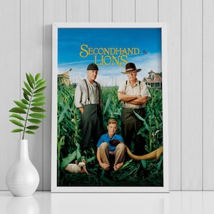 May include: Framed movie poster for "Secondhand Lions." The poster features three men standing in a cornfield, with the title in yellow text across the top. A young boy sits in front of them, and a dog rests at the bottom.