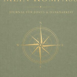 Könnte beinhalten: Ein salbeigrünes Journal mit goldfarbenen Buchstaben und einem Kompassdesign. Auf dem Cover steht "MEIN KOMPASS" und "JOURNAL FÜR FOKUS & DANKBARKEIT". Die Windrose ist zentriert, mit Richtungsanzeigern.