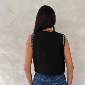 Chaleco negro de algodón bordado con detalles de botones. imagen 6