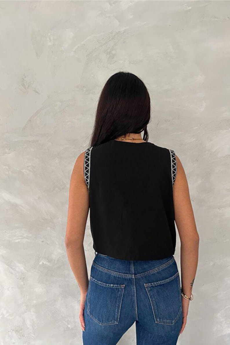 Chaleco negro de algodón bordado con detalles de botones. imagen 6