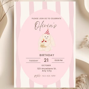May include: A pink and cream birthday invitation with vertical stripes. The invitation features the text "Please join us to celebrate Olivia's Birthday". A cartoon bunny holding a cupcake is in the center. The date and time are also included.