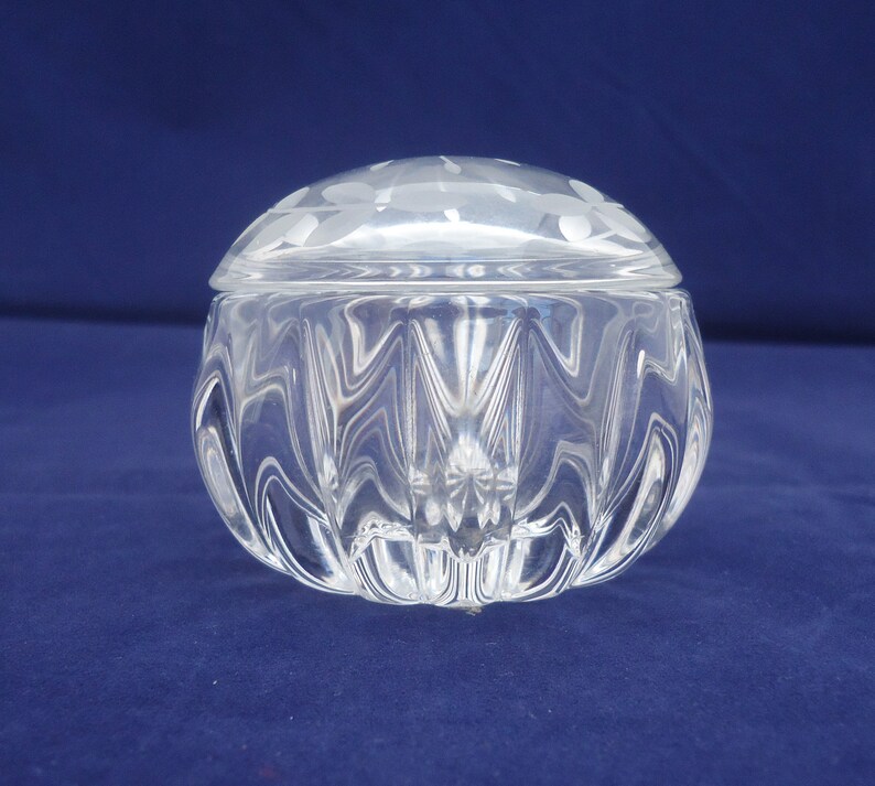 May include: A clear glass trinket box with a textured, faceted design. The lid has a frosted, etched pattern.