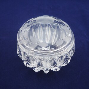 May include: A clear glass trinket box with a frosted lid. The lid has a floral design etched into it. The base of the box has a textured, wavy design.