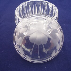 May include: A clear glass trinket box with a frosted etched design of a flower on the lid. The box has a fluted design on the sides.