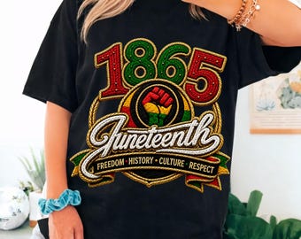 May include: Black t-shirt with a colorful Juneteenth graphic. The design features the year "1865" in red and green, the word "Juneteenth" in script, and a raised fist symbol. The shirt also includes the words "Freedom, History, Culture, Respect."