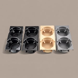 Puede incluir: Cuatro portavasos dobles en varios colores: fibra de carbono, negro, beige y gris. Cada unidad tiene dos aberturas circulares para bebidas. Los portavasos están hechos de plástico y están diseñados para uso automotriz.