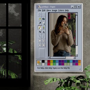 Może przedstawiać: Oprawione dzieło sztuki przedstawiające kobietę robiącą selfie, prezentowane w interfejsie programu "Paint" w stylu vintage. Interfejs zawiera pasek narzędzi z ikonami i paletę kolor&oacute;w. Tekst "untitled - Paint" jest widoczny u g&oacute;ry. Grafika jest na szarej ścianie.