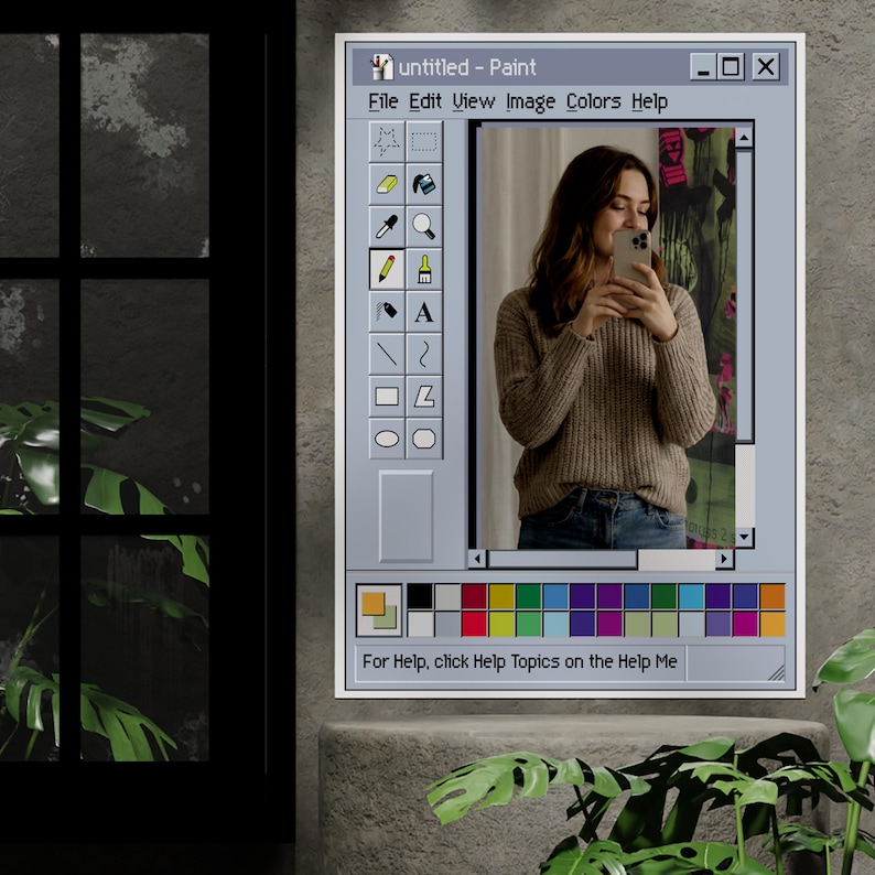 Może przedstawiać: Oprawione dzieło sztuki przedstawiające kobietę robiącą selfie, prezentowane w interfejsie programu "Paint" w stylu vintage. Interfejs zawiera pasek narzędzi z ikonami i paletę kolor&oacute;w. Tekst "untitled - Paint" jest widoczny u g&oacute;ry. Grafika jest na szarej ścianie.