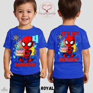 May include: Royal blue t-shirt featuring a cartoon Spider-Man holding a birthday cake with candles. The front of the shirt displays the number 4 and the name "DANNISON". The back of the shirt says "IT'S MY BIRTHDAY".