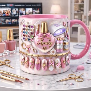 May include: A pink and white ceramic mug with nail art and manicure tools. The mug features a nail polish bottle design with the name "Amily" and is surrounded by nail polish bottles, brushes, and scissors. The mug is decorated with pink and gold accents.