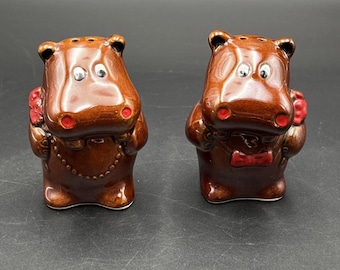 Salero y pimentero vintage marrón con forma de pareja cortejando a un hipopótamo