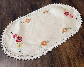 Tapete ovalado vintage con flores bordadas a mano y ribete de ganchillo.