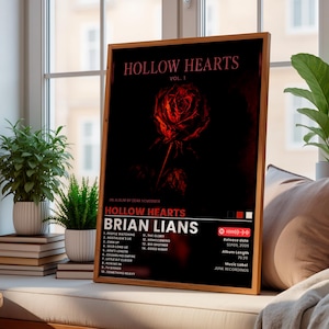 Pode incluir: Um cartaz retangular emoldurado com fundo escuro e uma ilustração central de uma rosa vermelha. O texto diz HOLLOW HEARTS VOL. 1, BRIAN LIANS, e uma lista de catorze músicas. Inclui a data de lançamento e detalhes da gravadora.