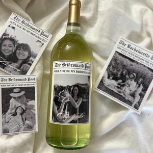 May include: A clear glass wine bottle with a custom label featuring a black and white photograph and the text The Bridesmaid Post, accompanied by three rectangular cards with black and white photos and headlines including The Bachelorette Times.
