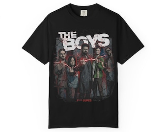 May include: Black t-shirt featuring the text "THE BOYS" in white block letters above a graphic of six people. The graphic has a distressed, textured background with red lightning bolts.